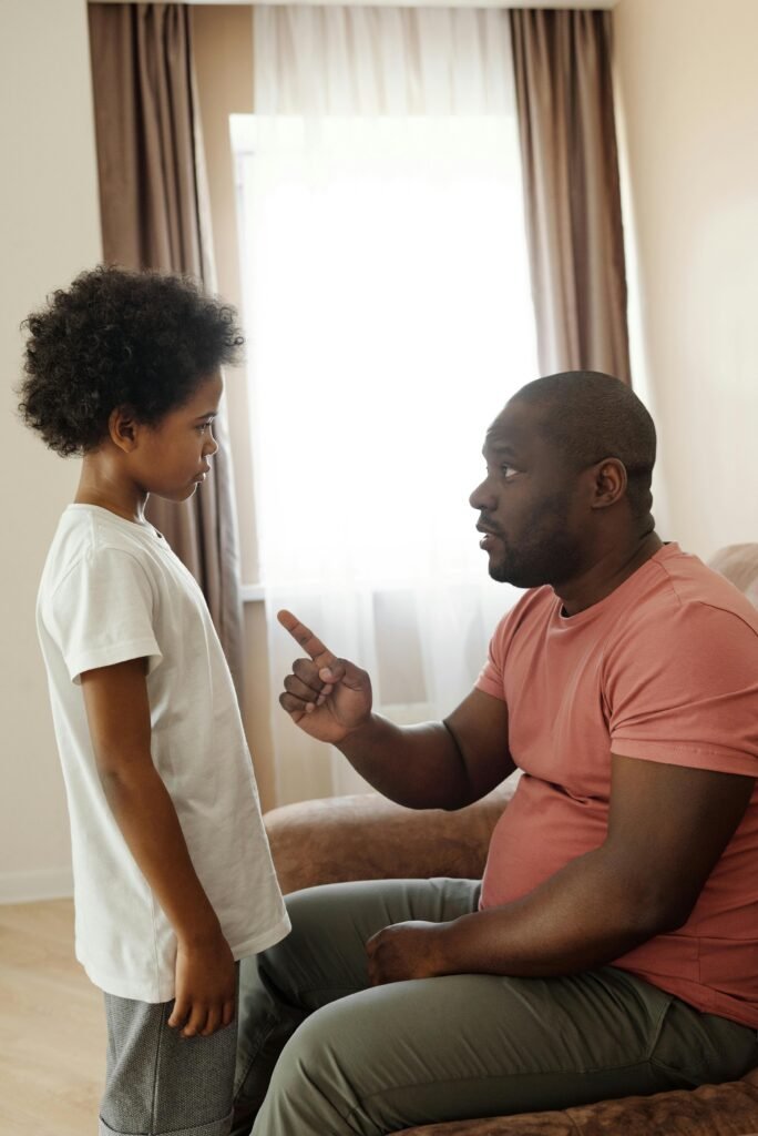 A father attentively explains to his son in a cozy living room setting.